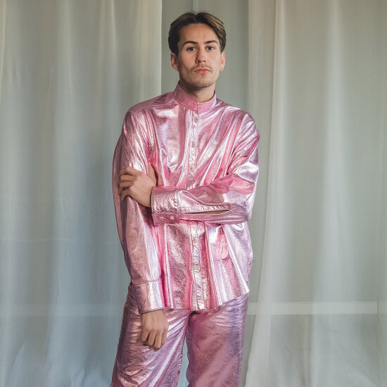 Rosa glinsende skjorte og bukse på mannlig modell. Laget av klesmerket Gobmi.